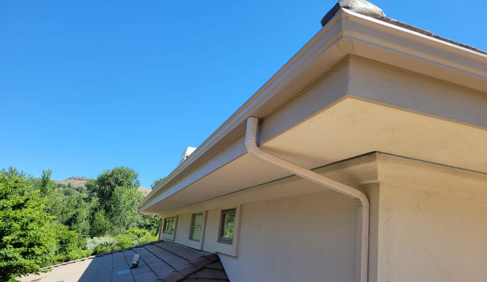 A house roof with a gutter system and downspout