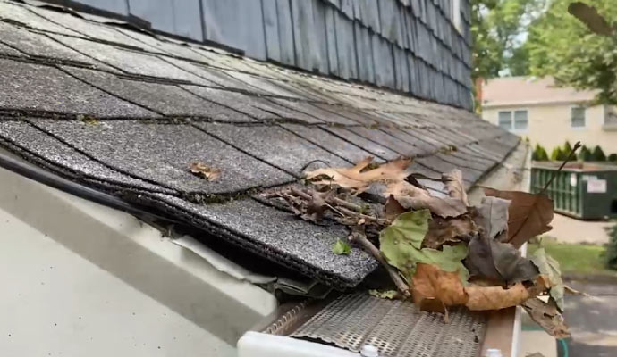 A dirty gutter attached to a house roof