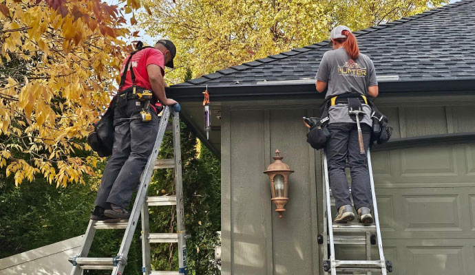 Person repairing a roof gutter system on a house