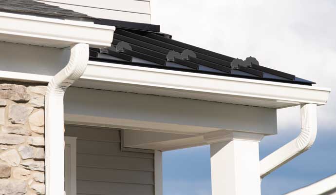 A white downspout installed on the exterior of a building