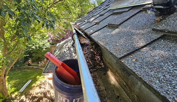 a house's gutter system being cleaned with equipment