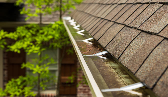 A house's roof watter overflowing on gutter in the roof