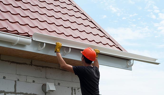  a man installing a rain gutter