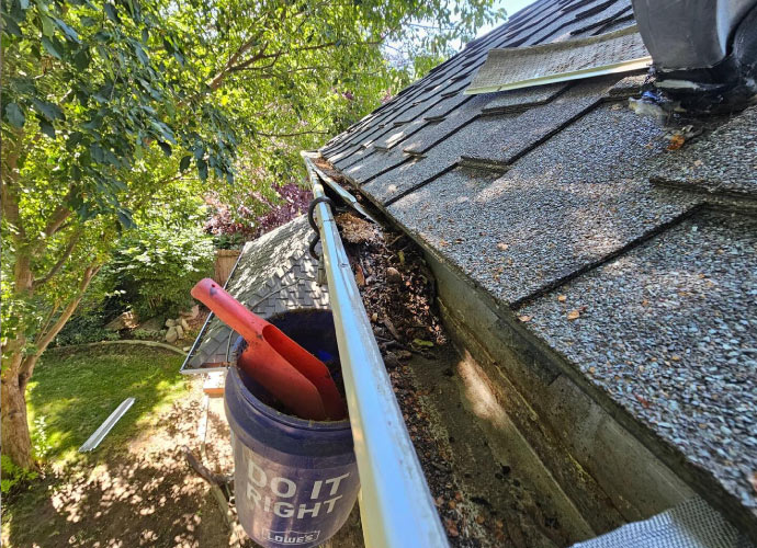 Person cleaning a gutter